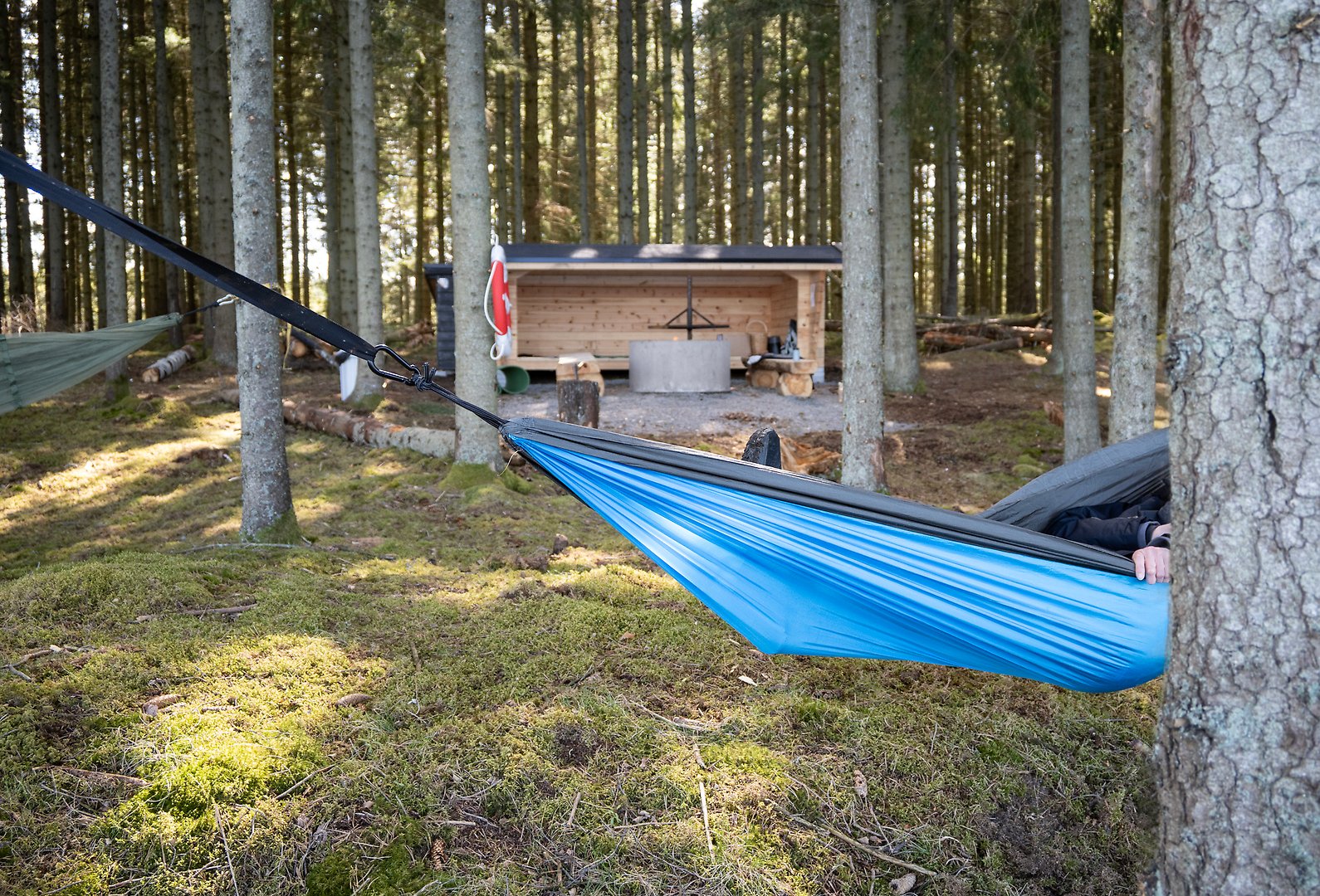 Kvinna lägger på ved på grillplats